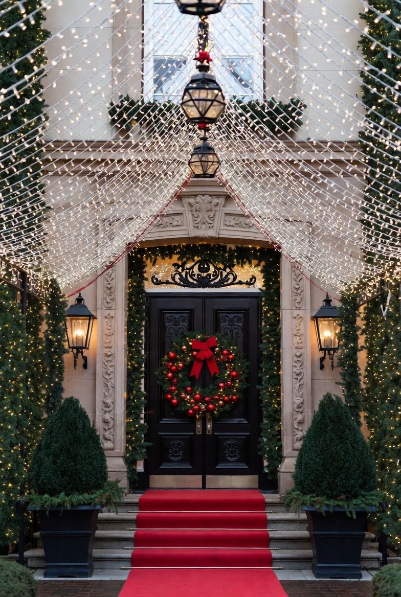 Concept: a formal entrance with garland, wreath and a red carpet