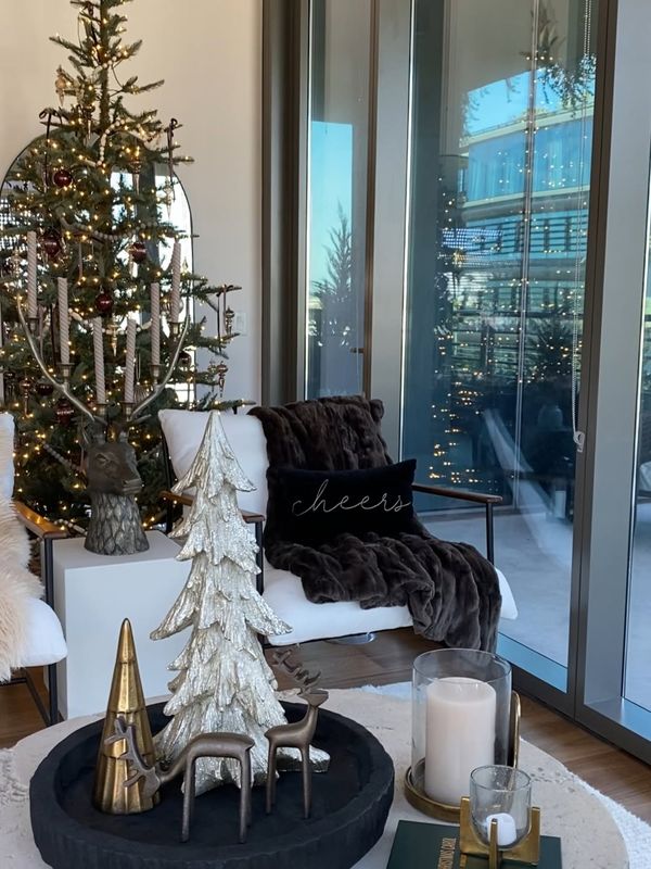 A styled corner with a tree, candles and a winter throw